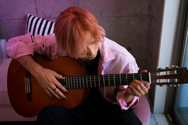 Medium shot boy playing the guitar