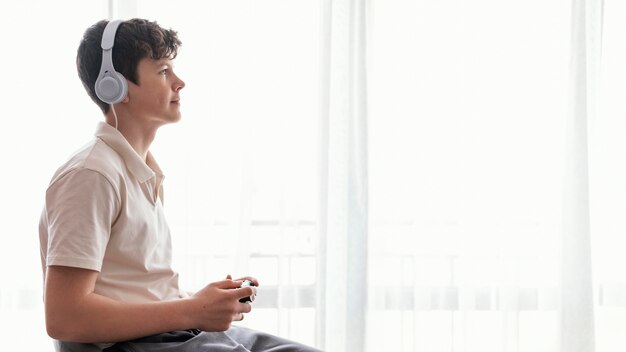 Medium shot boy playing videogame