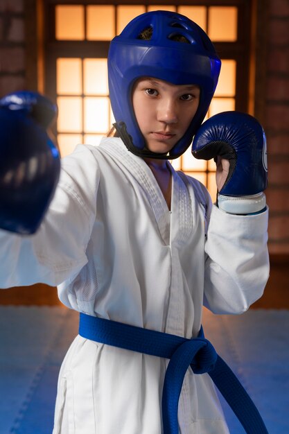 Medium shot boy practicing taekwondo