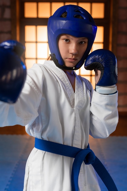 Medium shot boy practicing taekwondo