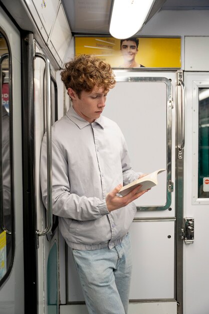 Medium shot boy reading in public transport