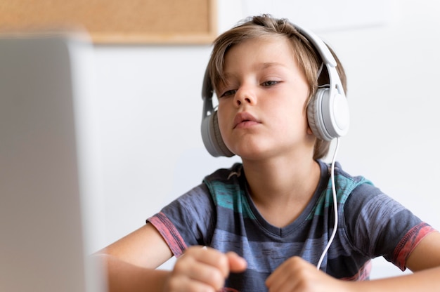 Foto gratuita ragazzo di tiro medio seduto alla scrivania