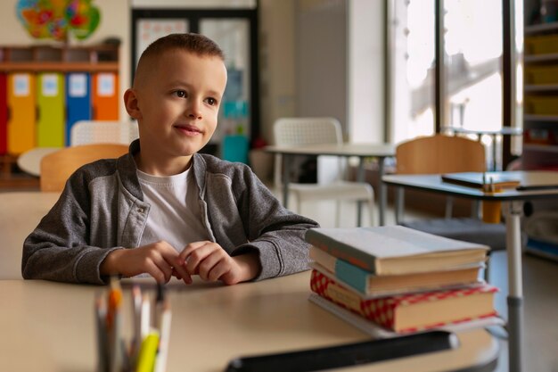 Medium shot boy sitting at school