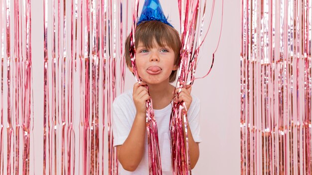 Medium shot boy wearing blue party hat