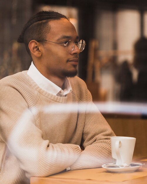 Free photo medium shot boy with glasses sitting indoors