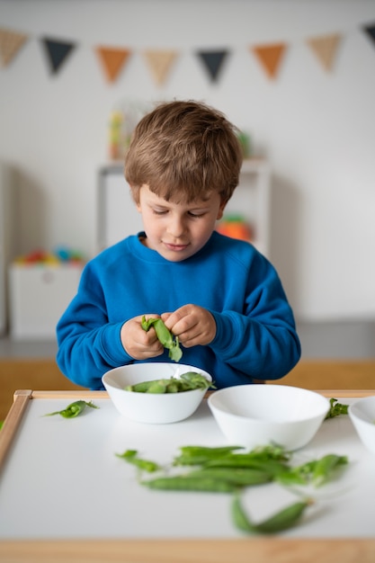 緑色の豆とミディアムショットの少年