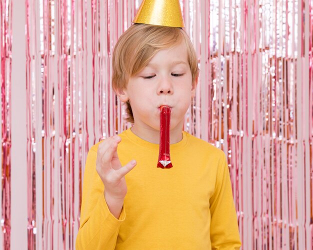 Medium shot boy with party whistle