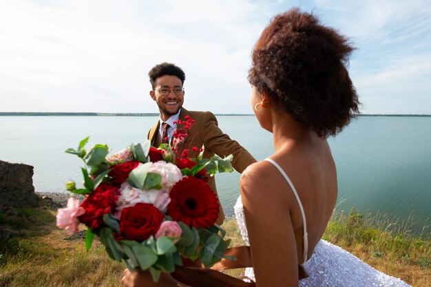 Medium shot bride and groom posing outdoors