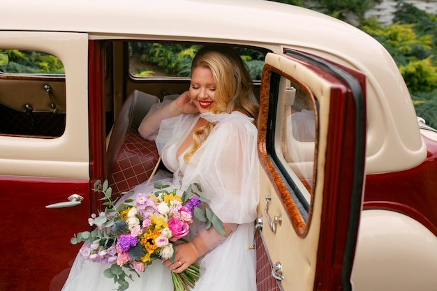 Medium shot bride posing in vintage car