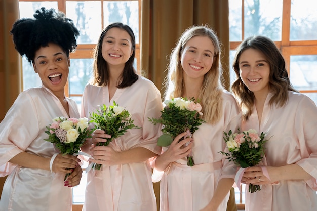 Medium shot bridesmaids holding flowers