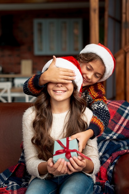 Free photo medium shot brother surprising sister with gift