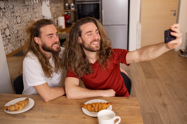 Medium shot brothers taking selfie