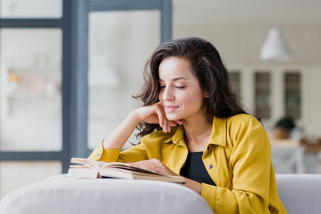 Medium shot brunette woman reading indoors