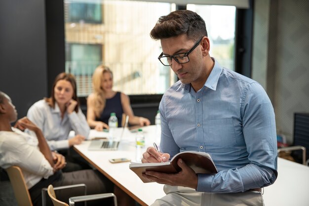 Medium shot business man writing in notebook