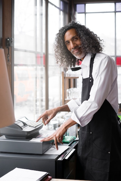 Medium shot business owner with cash register