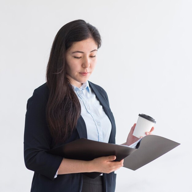 Medium shot business woman looking at file