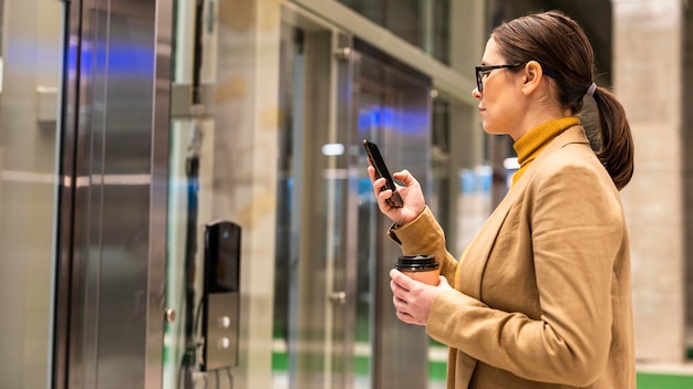 Foto gratuita donna d'affari di colpo medio con il telefono