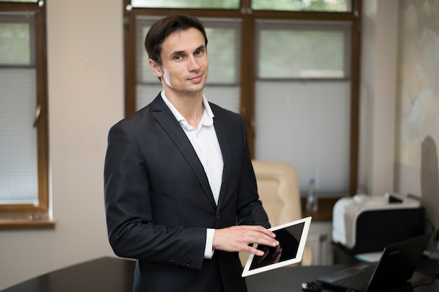 Medium shot of businessman using tablet