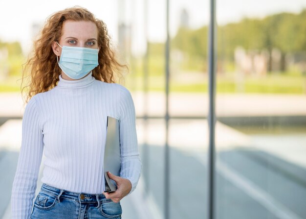 Medium shot of businesswoman wearing medical mask