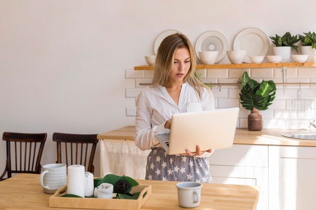 Средний снимок занятая женщина, держащая ноутбук