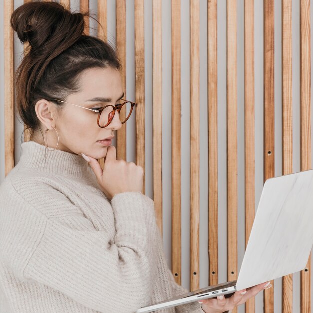 Medium shot busy woman holding laptop