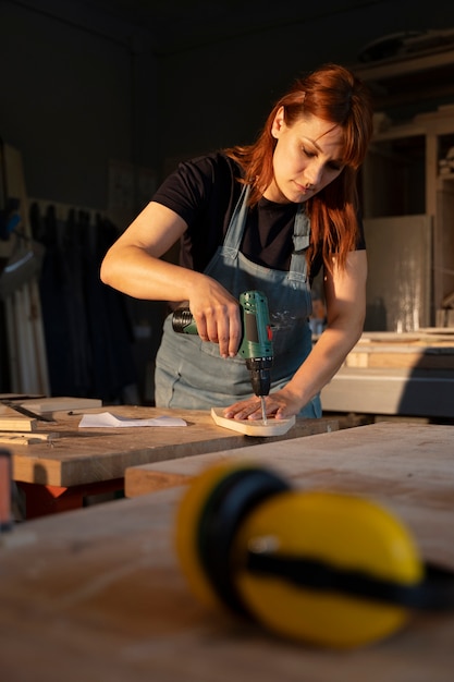 Medium shot carpenter working with drill