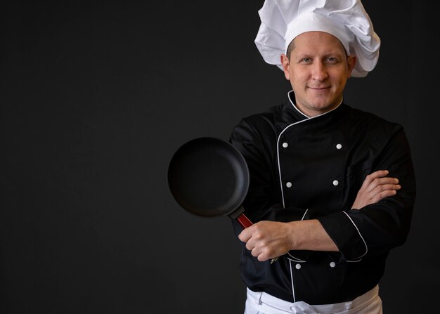 Medium shot chef with pan posing