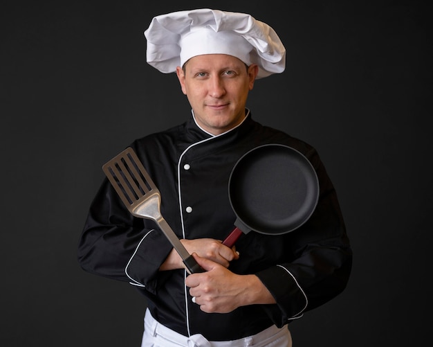 Шеф-повар среднего размера со сковородой и лопаткой