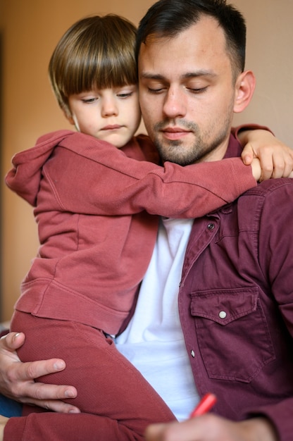 Foto gratuita bambino di colpo medio che abbraccia padre