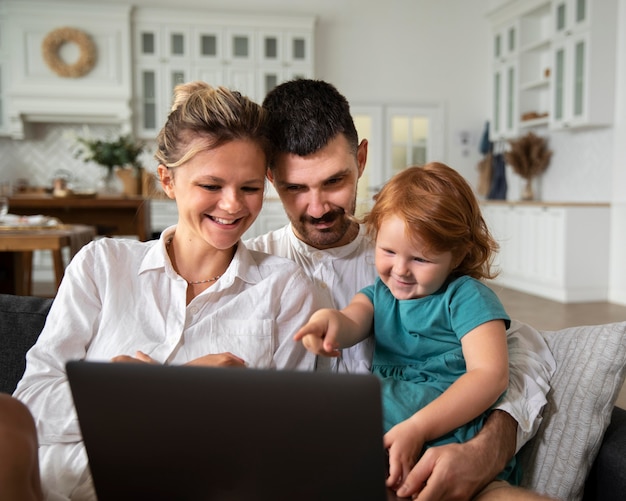 Medium shot child and parents with laptop