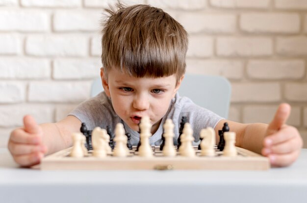 Medium shot child playing chess