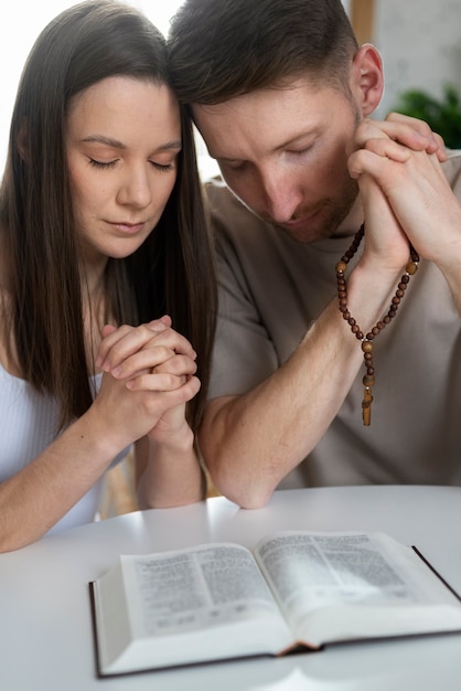 聖書を読んでミディアムショットのキリスト教のカップル