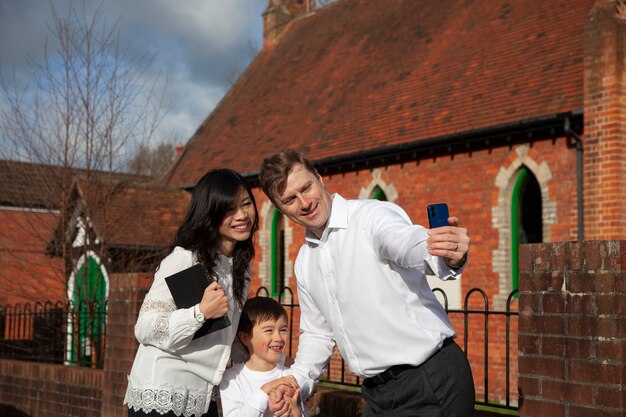 Medium shot christian family taking selfie