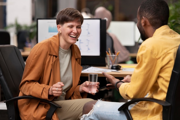 Medium shot colleagues laughing at work