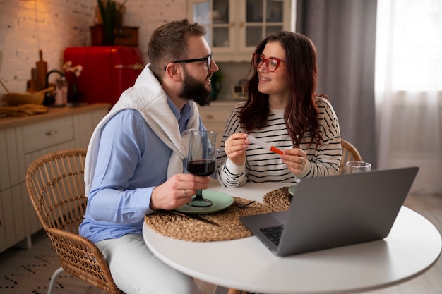 Medium shot couple announcing pregnancy with laptop