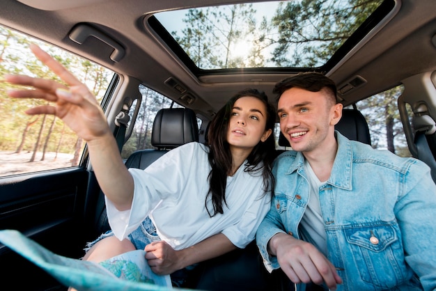 Medium shot couple in car with map