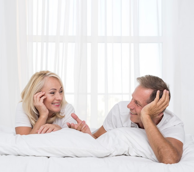 Medium shot couple chatting in the bedroom