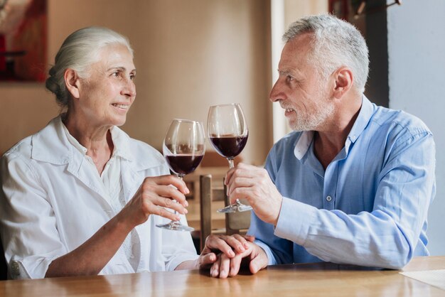 Medium shot couple clinking glasses