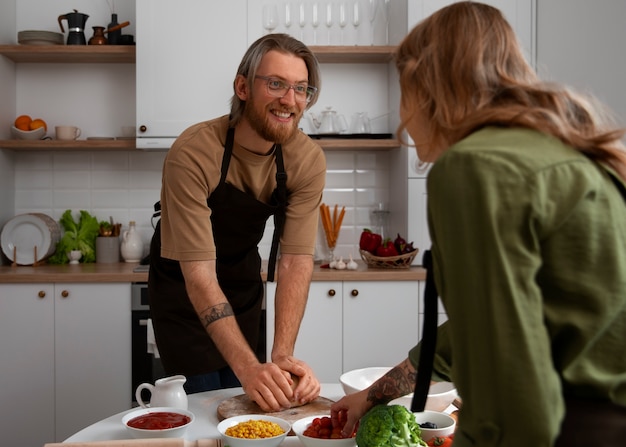 Foto gratuita coppie del colpo medio che cucinano insieme