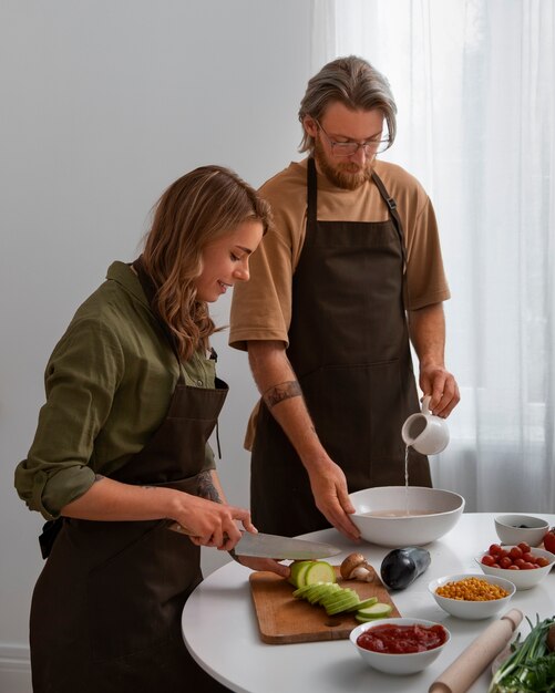 Medium shot couple cooking together