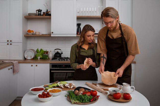 Free photo medium shot couple cooking together