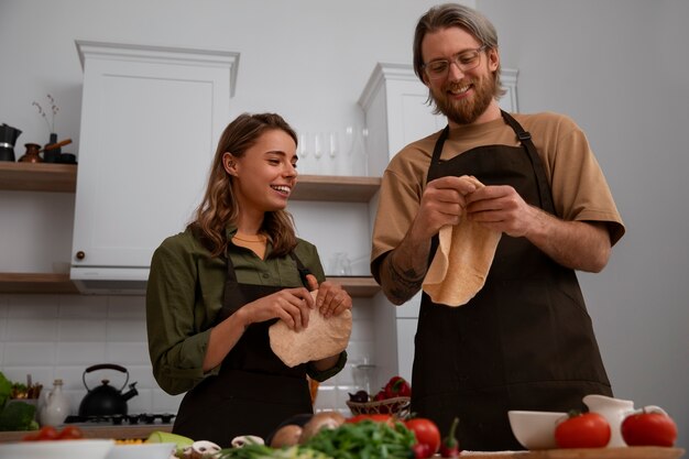 Medium shot couple cooking together