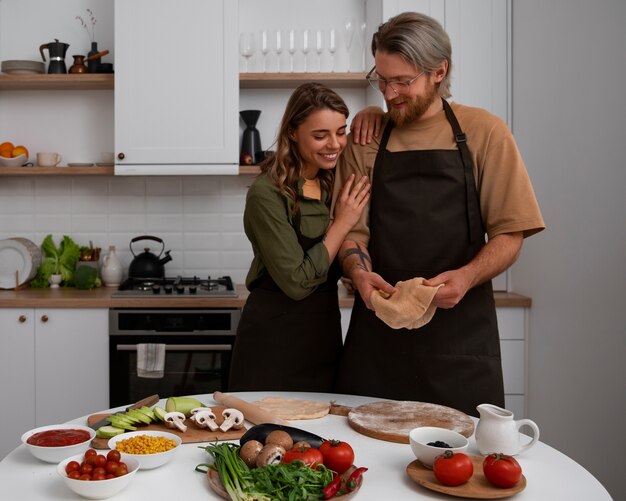 Medium shot couple cooking together