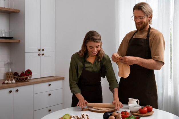 Medium shot couple cooking together