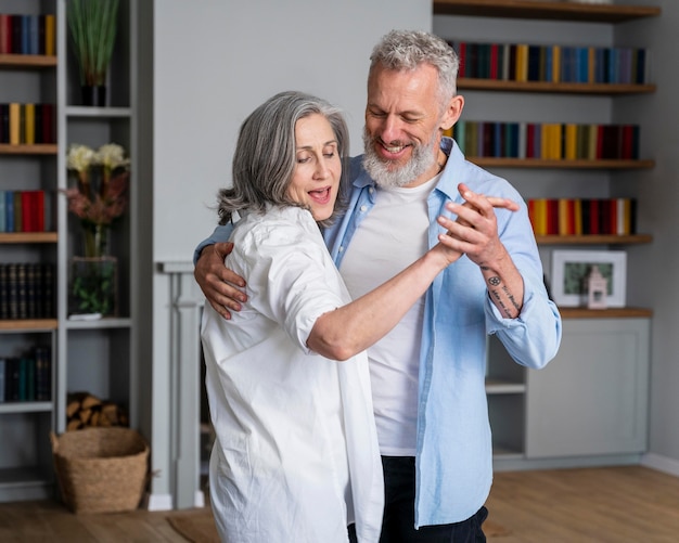 Medium shot couple dancing at home