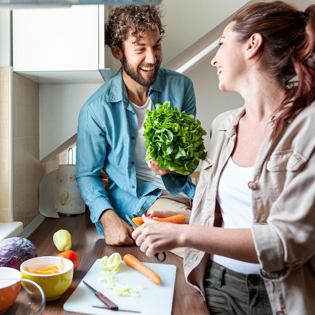 Free photo medium shot of couple having fun during cooking