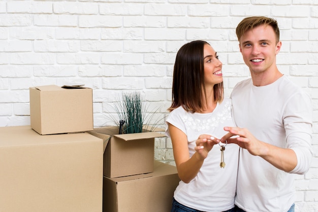 Free photo medium shot couple holding keys