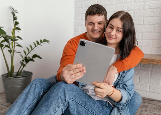 Medium shot couple holding tablet