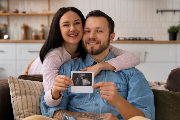 Medium shot couple holding ultrasound