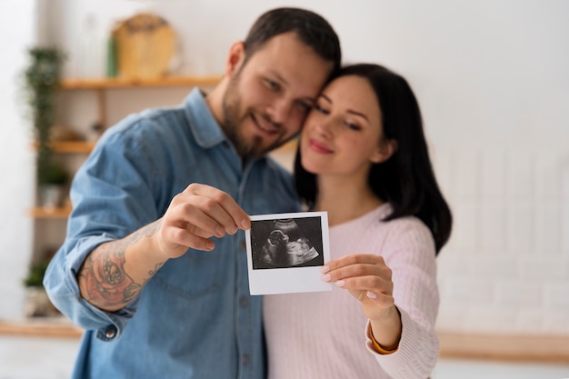 Medium shot couple holding ultrasound